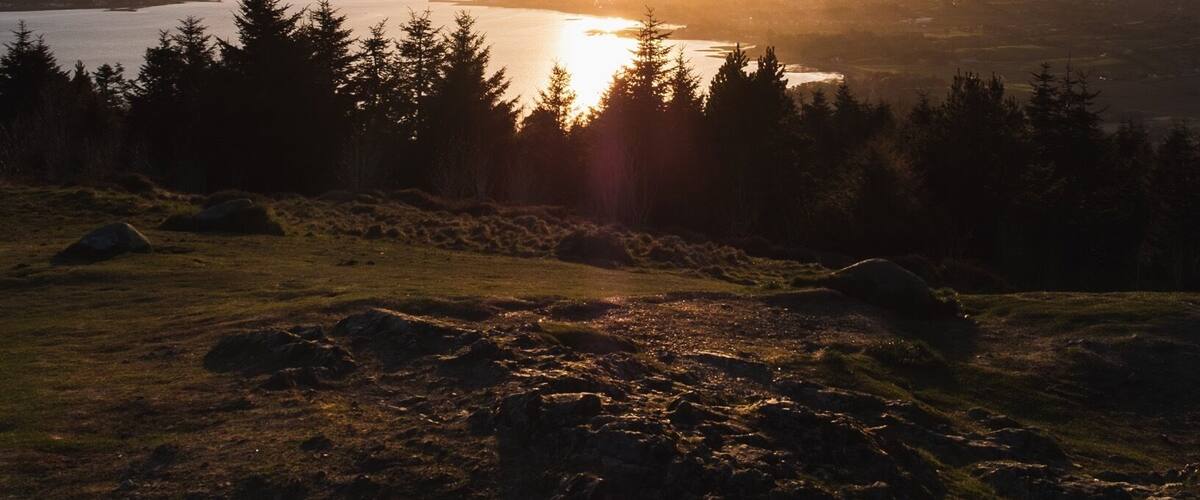 A sunset over a lake with mountains in the background.