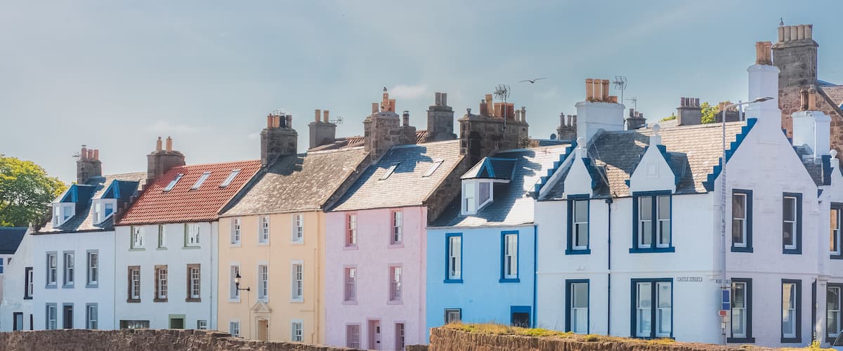 A colourful row of seaside houses on the sandy beach of the quaint coastal fishing village of Anstruther, East Neuk, Fife, Scotland, UK on a sunny summer day.