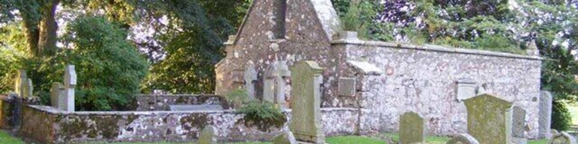 Una iglesia con un campanario y un cementerio de lápidas.