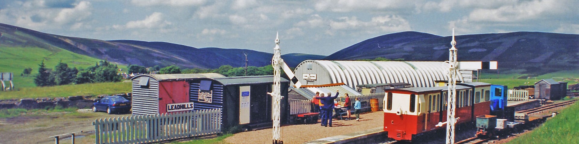 Leadhills: restored station, with narrow-gauge train, 2000. View NE, towards Elvanfoot: ex-Caledonian Railway Elvanfoot - Wanlockhead line, closed entirely 2/1/39, but restored by the heritage Leadhills & Wanlockhead Railway (2 ft. gauge).