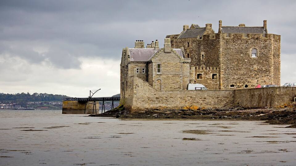 A historic stone castle by a river.