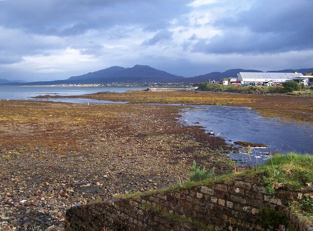 Broadford River enters the bay The old pier is in the centre of the photograph. The silver building on the right is the Co-op supermarket.