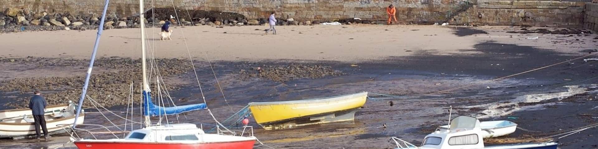 A beach with boats and fishing nets.