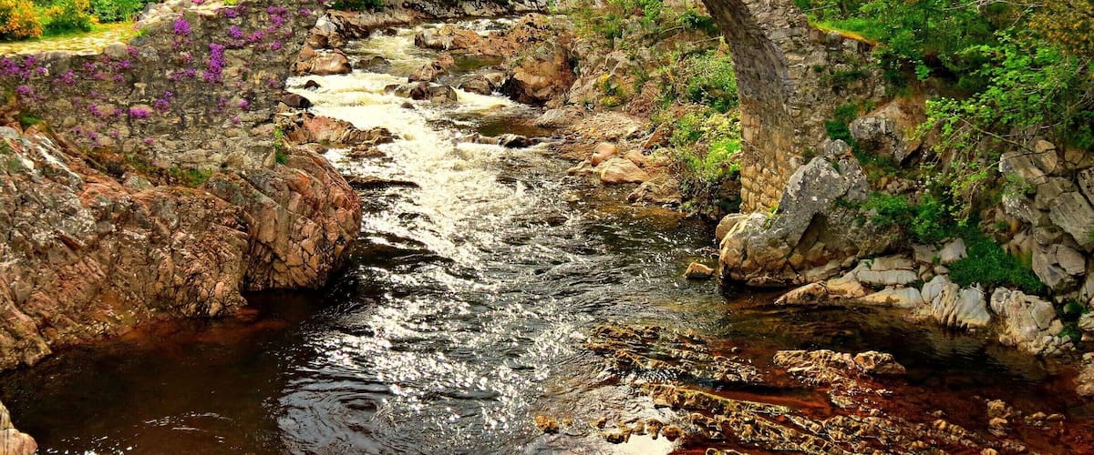 📍Old Packhorse Bridge, Carrbridge
The centre piece of Carrbridge, this is a famous landmark recognised by many of people, it is a hotspot for the locals to go swimming and even jumping off the bridge on a warm day.
The old packhorse bridge in Carrbridge in the Cairngorms National Park is the oldest stone bridge in the Highlands.
At the beginning of the eighteenth century, to the inconvenience of both travellers and local people, there was no point at which the River Dulnain could be crossed when it was in spate, and burials at the Church of Duthil were often delayed.
Brigadier-General Alexander Grant of Grant, Clan Chief, commissioned John Niccelsone, a mason from Ballindaloch, to build a bridge at Lynne of Dalrachney. Built between May and November 1717, the bridge was paid for out of stipends of the Parish of Duthill.
Its parapets and side walls were badly damaged in the 18th century and again in the famous flood of August 1829, giving the appearance it still has today.
#Aquatrove