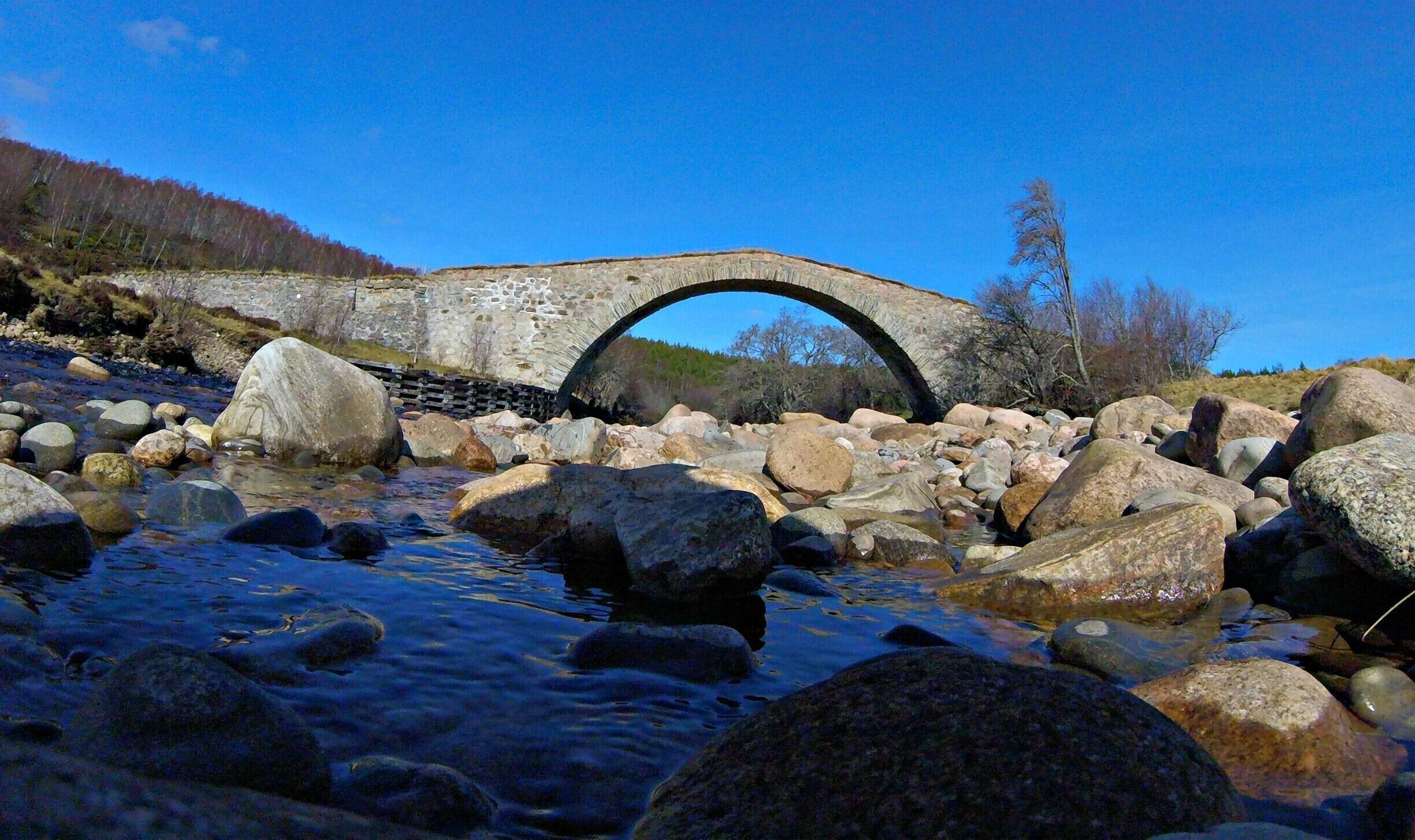 📍Sluggan Bridge, Carrbridge

The less famous and largely unknown bridge associated with Carrbridge, Sluggan Bridge crosses the Dulnain River on the old General Wade Military road c1729 two miles upstream from Carrbridge. Wade originally crossed the Dulnain with a ford which was later replaced in the 1760s with a two-arch bridge. This was swept away during the great flood of the 3rd of August 1829, to be replaced by the current large single span bridge in the 1830s. The bridge has undergone a major repair in 2001 - 2002, by Sustrans as part of the National Cycle Network. Sluggan Bridge is category A listed and a scheduled monument. The Wade Road is an ancient right of way. The Highland Council Archaeology Unit identifies, protects, promotes and interprets the archaeological heritage of the Scottish Highlands for the benefit of residents and visitors. We provide information and advice on archaeology - especially the conservation, management and interpretation of historic sites, monuments and landscapes. A short walk up river you will find a small beach, well very small beach and a nice deep pool for a swim on a warm day. 
#Aquatrove
