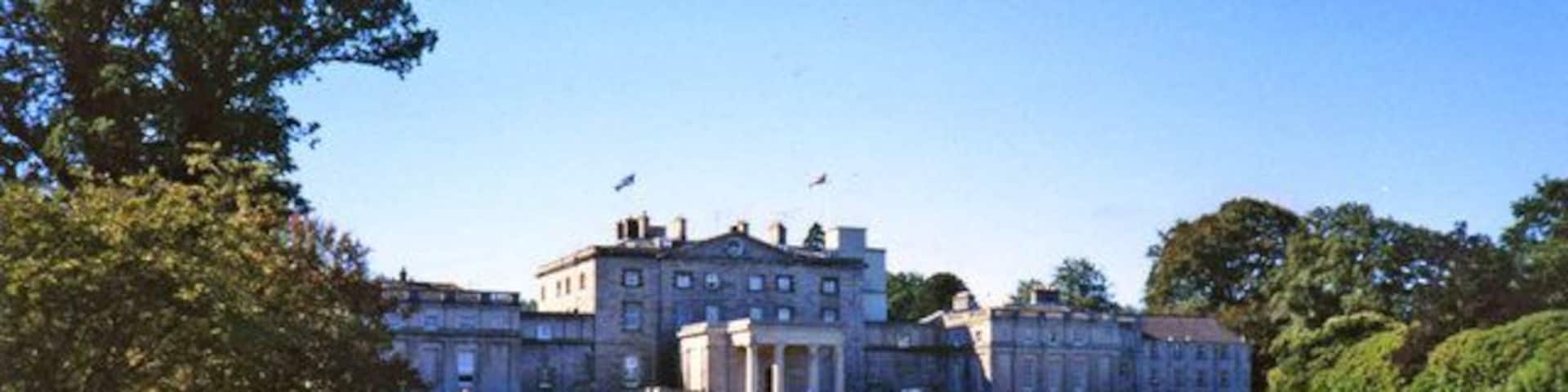 A large, historic building with a lawn in front.