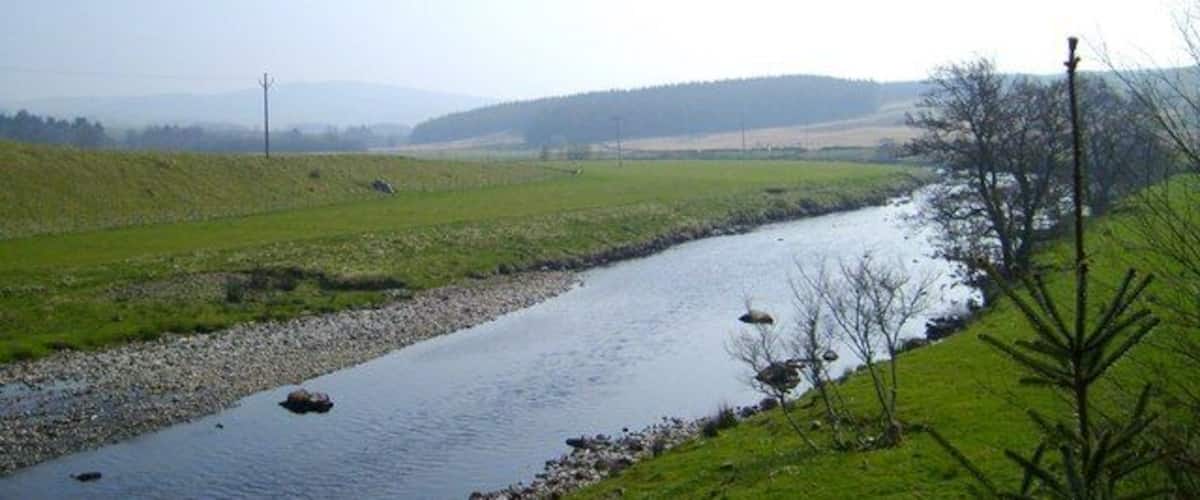 Water of Deugh at Carsphairn Water of Deugh from the bridge at Carsphairn with the wooded Cumnock Knowes in the distance