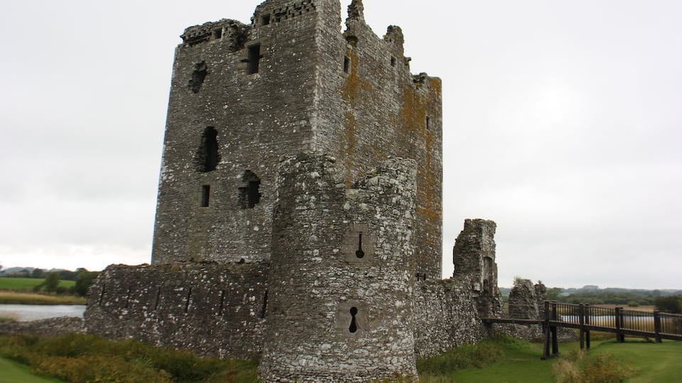 A large, historic stone castle with multiple towers and a moat.