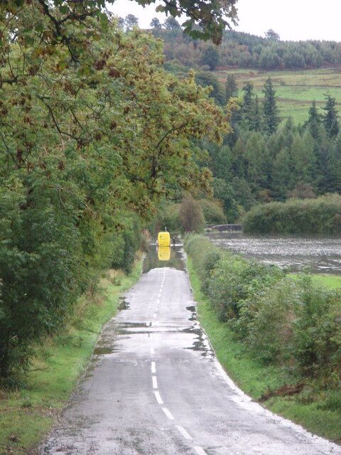 Flooding on the A762 Heavy rains created high water levels in the River Ken which in turn caused a minor tributary, the Coomb Burn to spill over its banks and flood the A762, causing delayed parcel deliveries for this unfortunate driver.