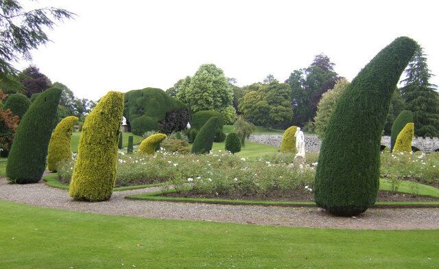 A formal garden with topiary sculptures and manicured lawns.