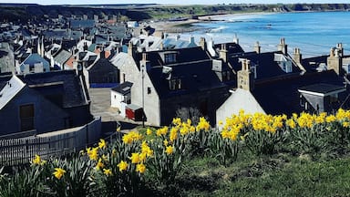 A coastal town with stone buildings, a bridge, and a beach.