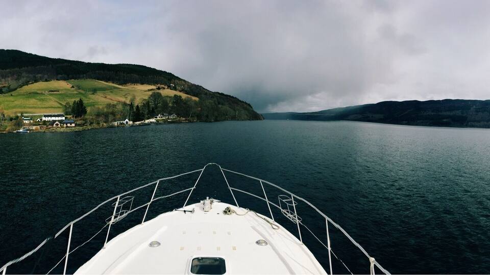 A boat on a calm lake with a mountainous landscape in the background.