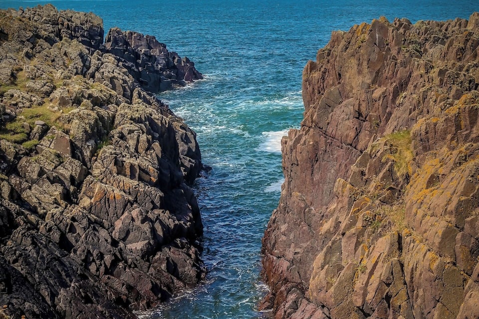 A rocky coastline with waves crashing against the rocks.