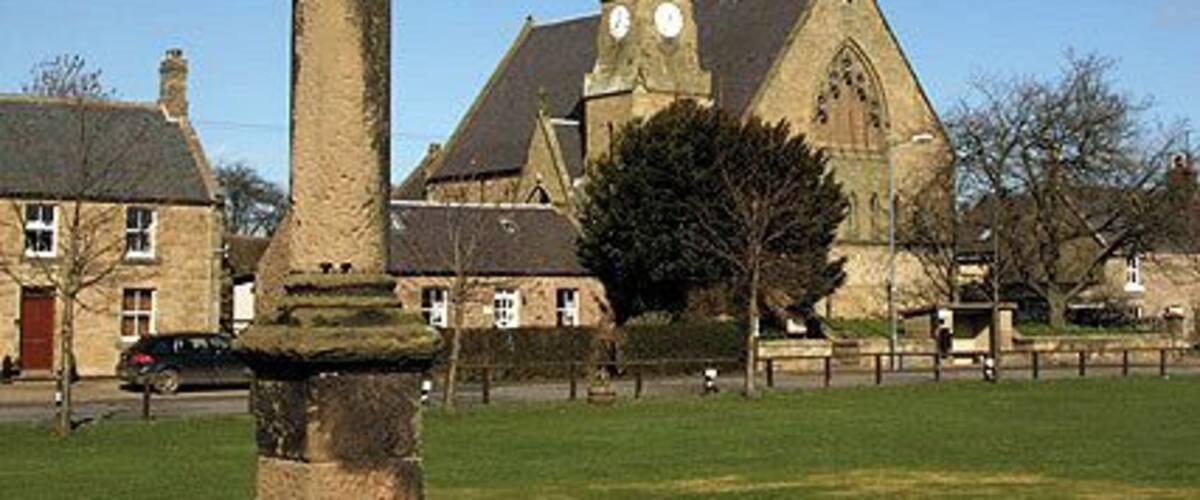 Swinton Village Cross Situated in the village green, this 1769 classical sundialed column is known as the 12th Man of Swinton. (Source: Borders and Berwick, an Architectural Guide by Charles Alexander Strang). The large building behind on the right is the former Free Church built in 1860, but is now used as the village hall. This had a very striking tall spire which could be seen from all around the Eastern Borders, but the top of the spire had to be removed for safety reasons. (Source: Swinton Kirk information leaflet). At the time of visiting there was a notice on the hall door stating that the building was not available for public use until further notice.