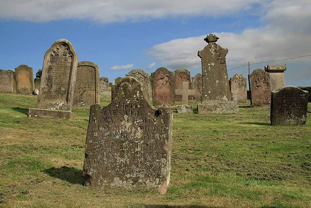 A cemetery with various stone monuments and crosses.