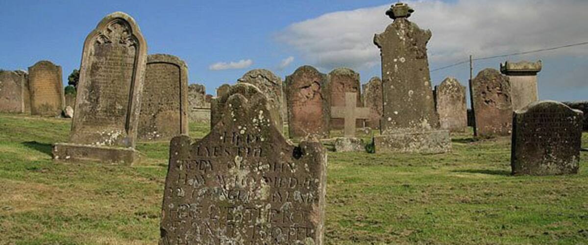 A cemetery with various stone monuments and crosses.