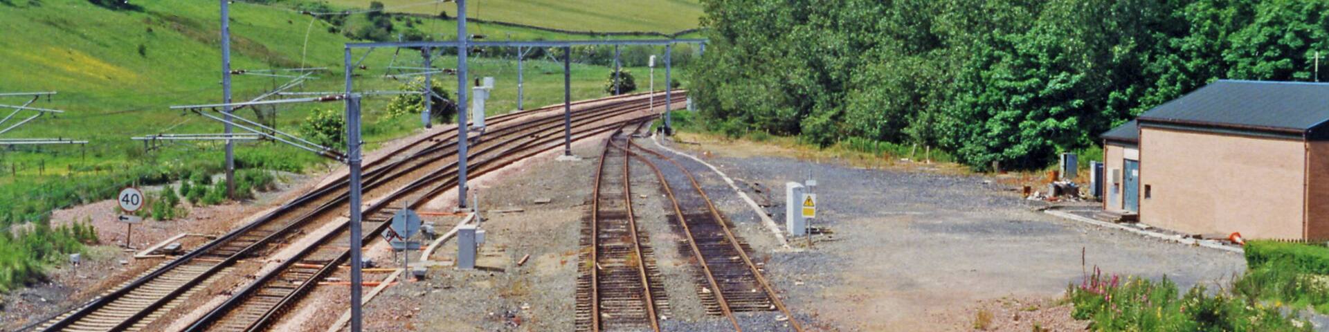 Site of former Grantshouse station, East Coast Main Line 1997. View westward from the A6112 bridge, towards Edinburgh: ex-NBR (Edinburgh - Berwick) section of the ECML. The station was closed to passengers 4/5/64 (to goods 28/12/64), long before electrification of the line in 1991.