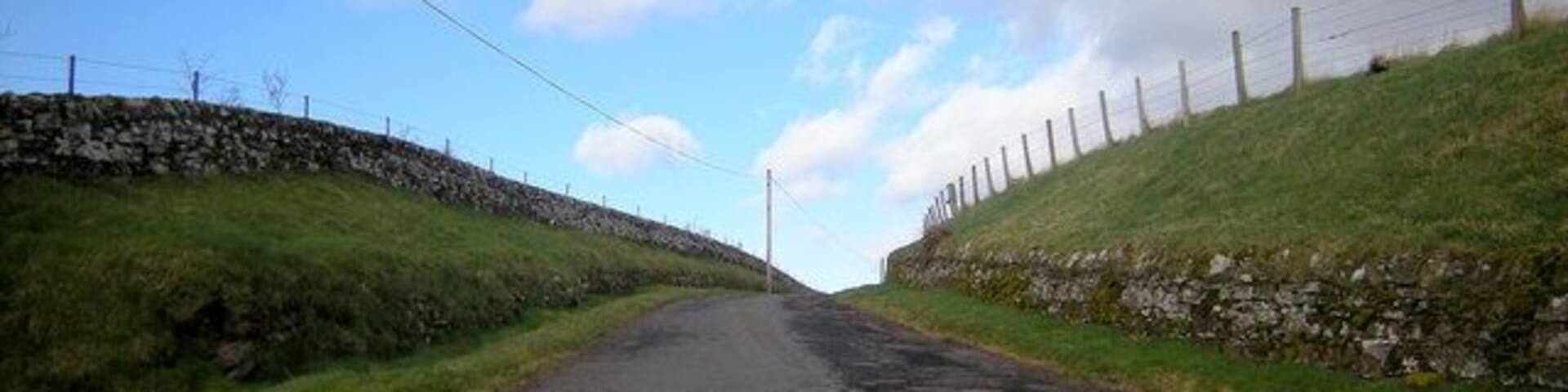 View of Broom Farm Road from Glen Ogil / Tannadice Road This road also doubles as a footpath to Wellgate. Wellgate is situated on the Kirriemuir / Brechin Road near its junction with the road leading to Finavon.