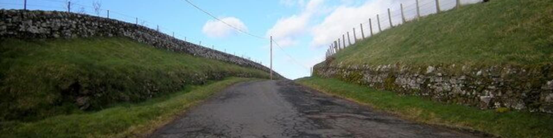 View of Broom Farm Road from Glen Ogil / Tannadice Road This road also doubles as a footpath to Wellgate. Wellgate is situated on the Kirriemuir / Brechin Road near its junction with the road leading to Finavon.