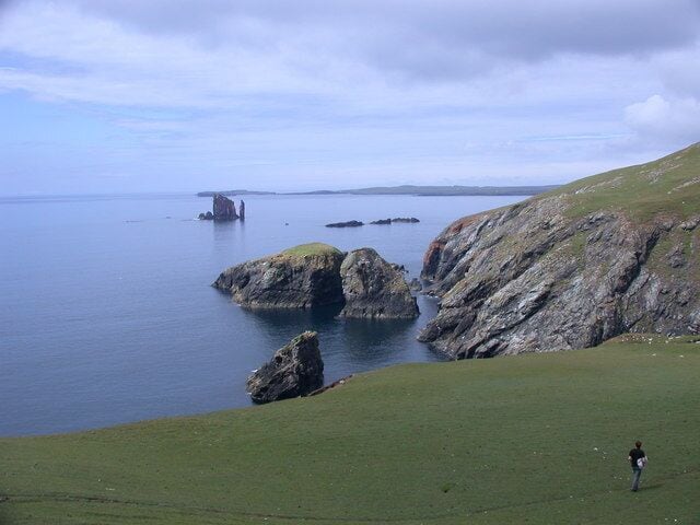 Ness of Hillswick, SW coastal cliffs SW cliffs of Ness of Hillswick on right, Isle of Niddister in centre. The Drongs HU2675 rock stacks beyond, with the South edge of Esha Ness on the horizon to their left.
