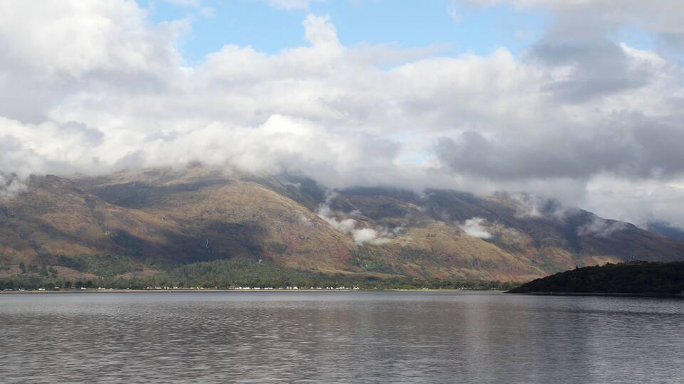 A mountain range with a lake in the foreground.