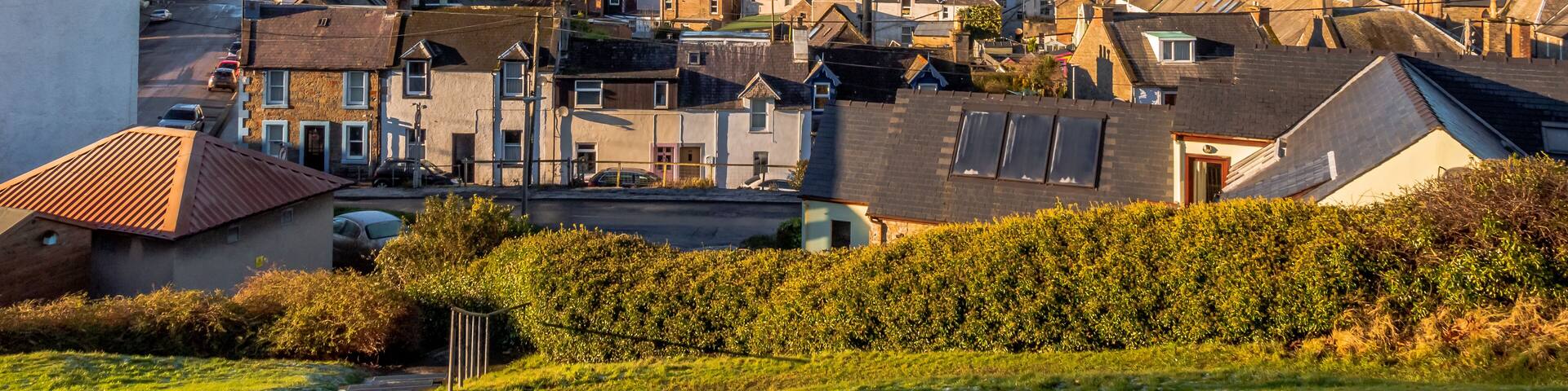 A coastal town with historic buildings, a church spire, and a marina.