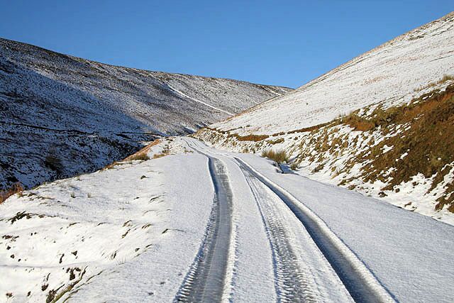 A snow-covered road winding through a mountainous landscape.