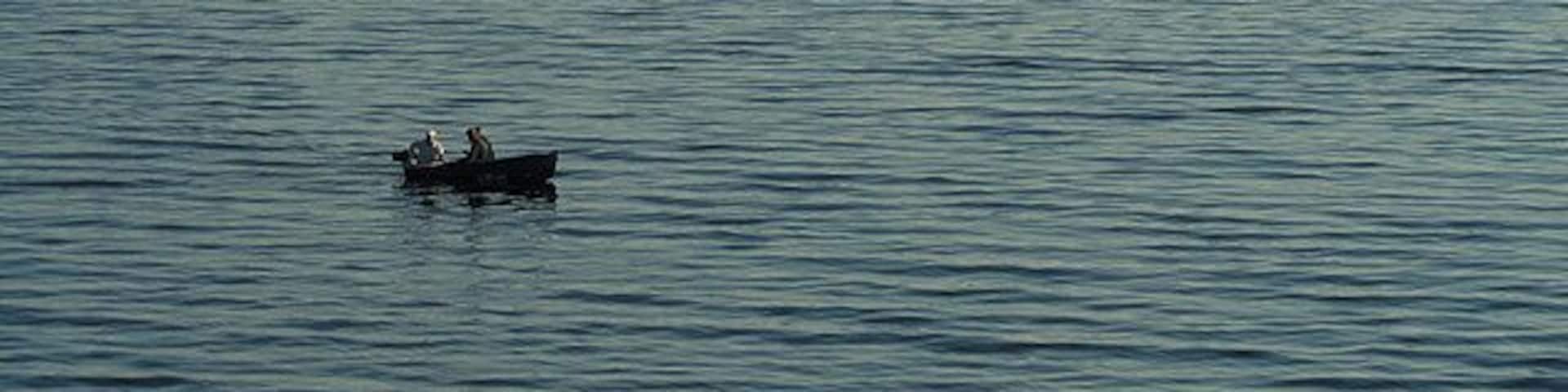 Fishing in Ardmucknish Bay These anglers in the small boat are enjoying calm evening conditions on the bay. Viewed from the A828 at Benderloch in early June.