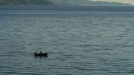 Fishing in Ardmucknish Bay These anglers in the small boat are enjoying calm evening conditions on the bay. Viewed from the A828 at Benderloch in early June.