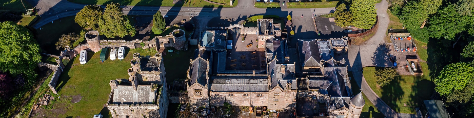 Vista aérea de um castelo histórico cercado por um parque com instalações de camping.