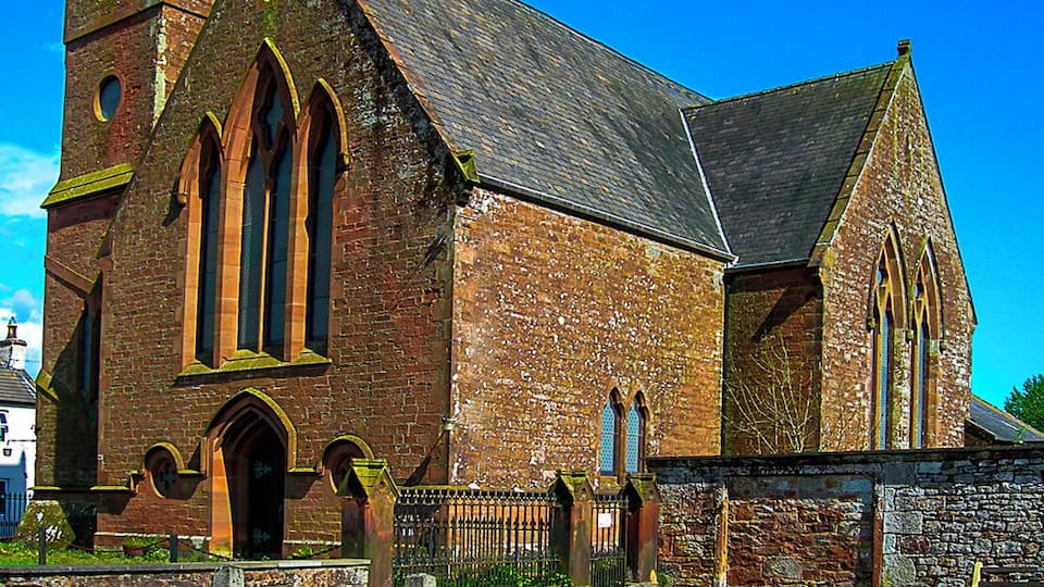 A historic church with a prominent steeple and arched windows.
