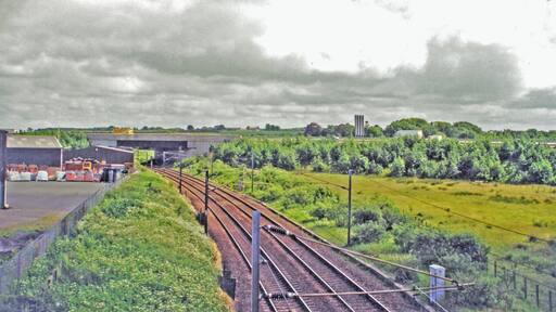 Site of former Kirtlebridge station, WCML 2000. View southward from B722 to the large bridge of the new A74(M). This is situated where the station had been, until it closed 13/6/60 to passengers (6/4/64 to goods). The view is up the ex-Caledonian Railway (Glasgow - Carlisle) section of the West Coast Main Line, electrified 1974. Off to the right used to be the branch line to Annan (Shawhill) and over the Solway Viaduct to Brayton on the Maryport & Carlisle Railway; this lasted to Brayton only until 20/5/21, to Annan for passengers until 27/4/31 (goods 28/2/55, however).