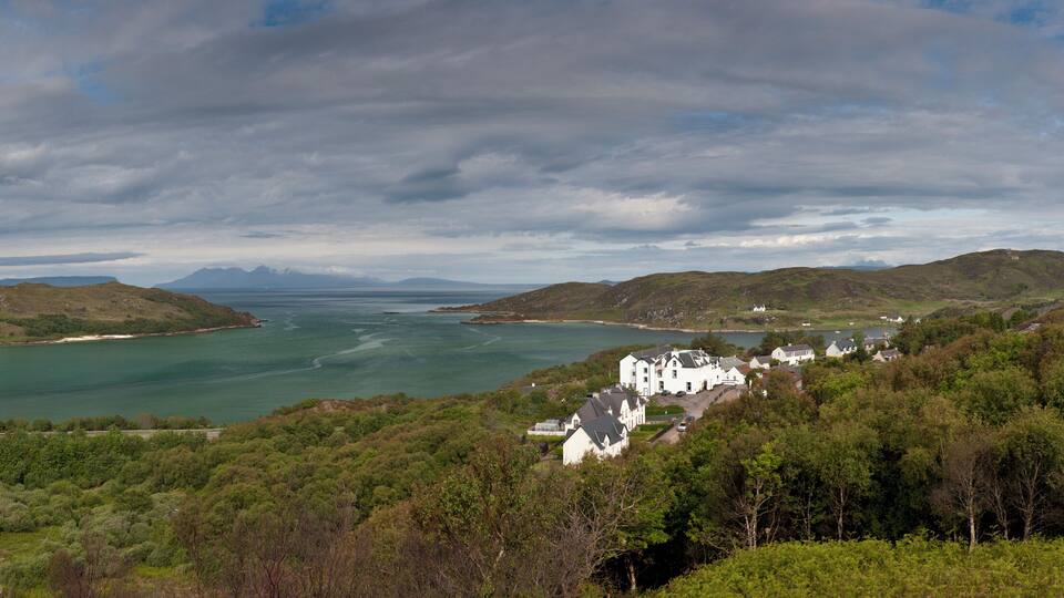 A coastal landscape with hills, a bay, and a small settlement.