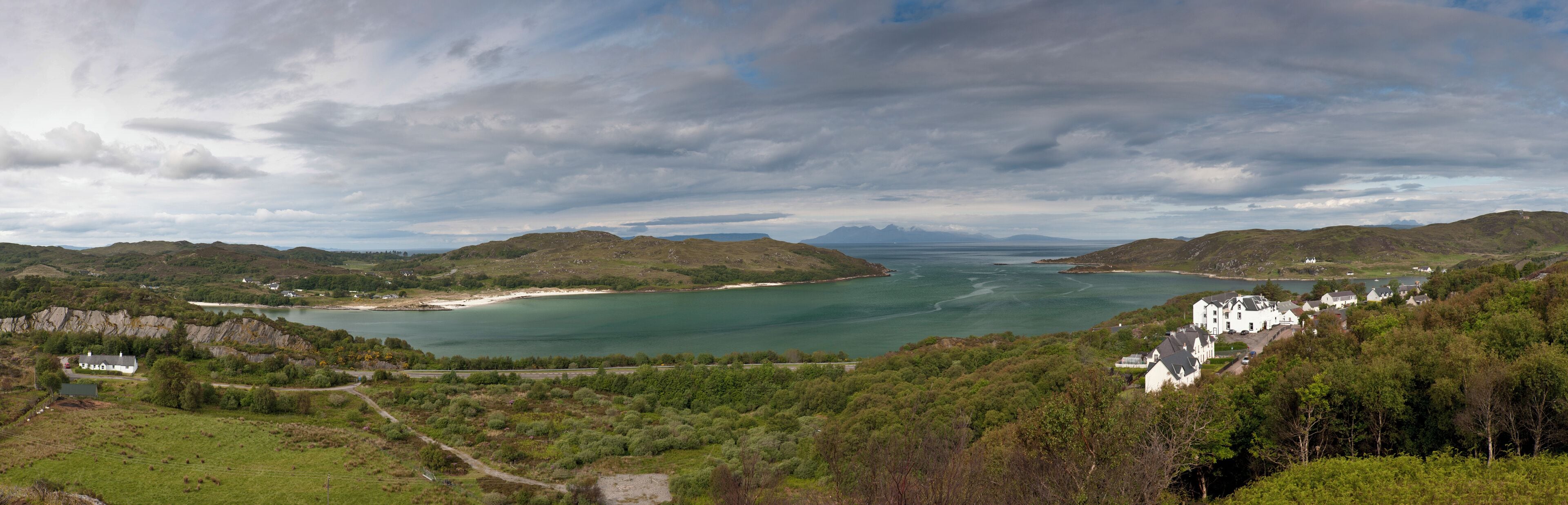 A coastal landscape with hills, a bay, and a small settlement.