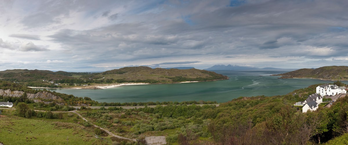 A coastal landscape with hills, a bay, and a small settlement.