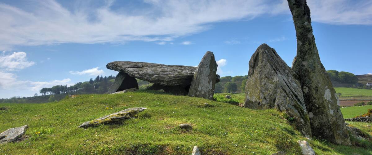 A stone circle on a grassy hill with a clear sky.