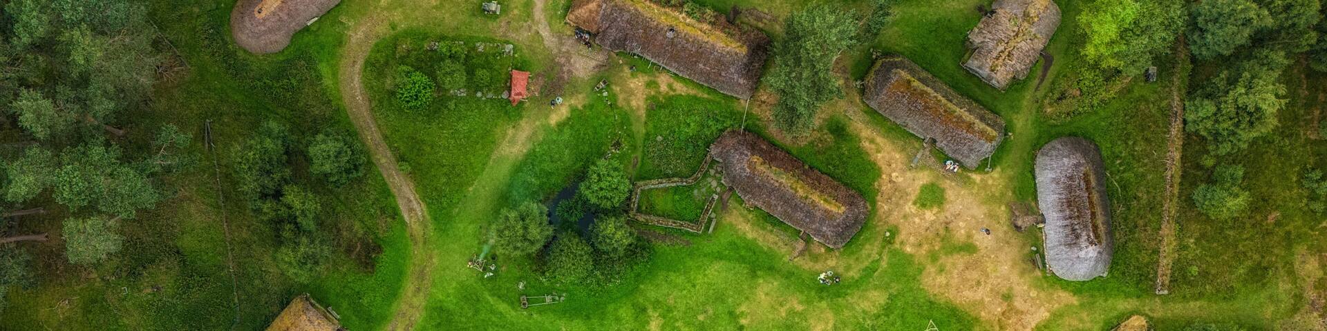 An aerial view of a historical site with ruins, pathways, and surrounding greenery.