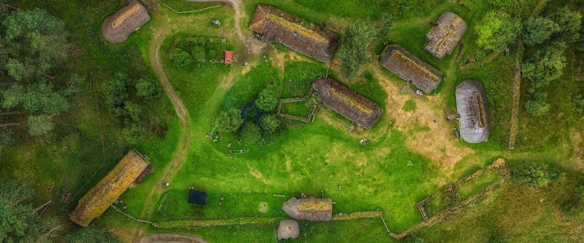 An aerial view of a historical site with ruins, pathways, and surrounding greenery.
