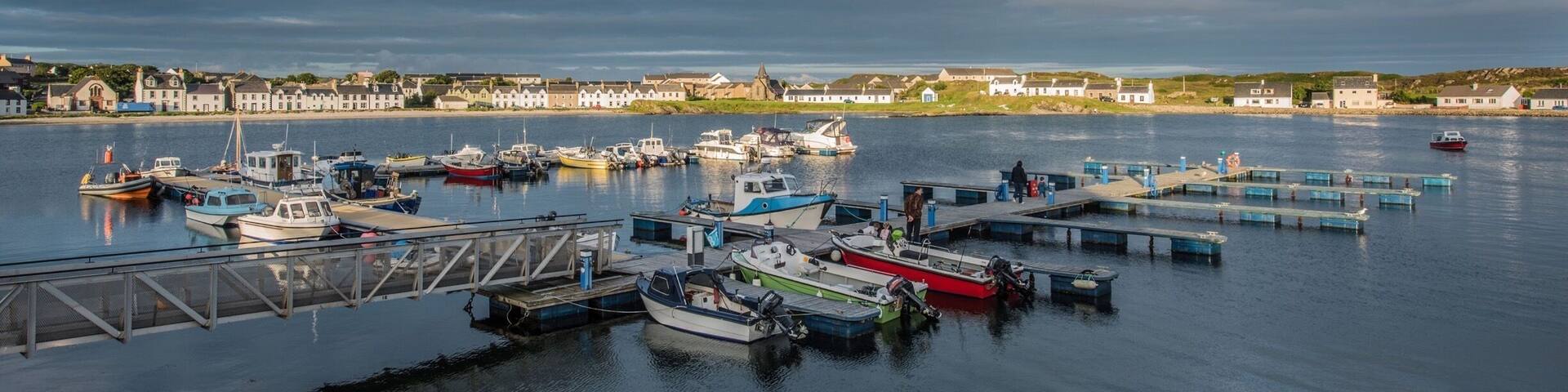 Port Ellen on Islay, Scotland. It's a town on the southern coast of Islay. It's location could be described as a bay within a bay.
It's a small town with three pubs, only one of which is worth visiting as it's been recently renovated. There are plenty of accommodation houses and a very pretty harbour. Early mornings are busy as boats are made ready for the days adventures or work.
As many visitors come to Islay without a means of personal transport the local council, with added funds from each distilleries, has built a sealed pathway beside the road to the nearby Laphroaig, Lagavulin and Ardbeg distilleries.