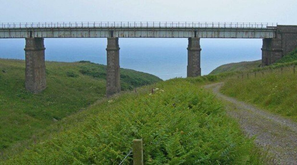 Masonry piered railway bridge over burn north of Muchalls, Kindardineshire The North Sea is in the background. Service road at right is used for water works access.