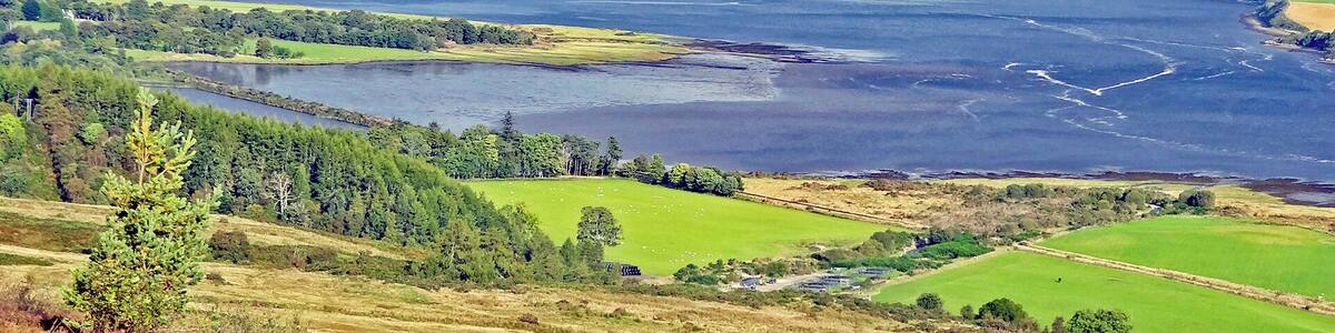 view from the B9176 over Dornoch Firth with Loch Migdale in the far side and a wind farm on the hilltops in the background