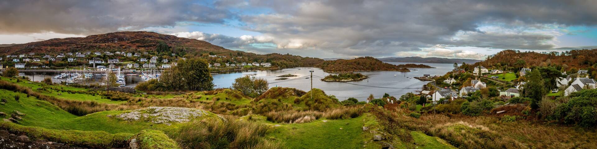 Sweeping panorama from the top of the hill next to Royal Castle Tarbert looking down at the bay and small city of Tarbert in Argyll and Bute Scotland United Kingdom