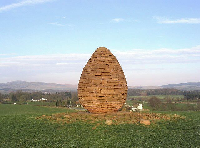 Millennium Cairn Situated a short distance east of Stepends Farm near Penpont with houses at Burnhead in the background. According to a worker on the farm, this was erected to celebrate the new millennium. Taken late in the afternoon on a fine March day. A site visitor adds:- This sculpture is the work of the famous artist Andy Goldsworthy who lives in nearby Penpont.