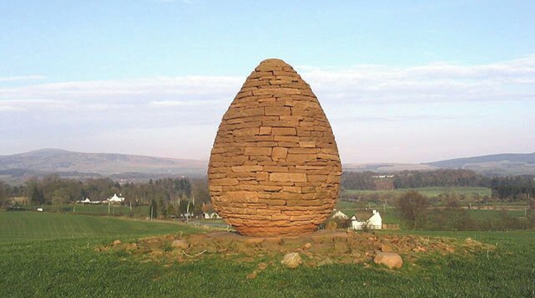 Millennium Cairn Situated a short distance east of Stepends Farm near Penpont with houses at Burnhead in the background. According to a worker on the farm, this was erected to celebrate the new millennium. Taken late in the afternoon on a fine March day. A site visitor adds:- This sculpture is the work of the famous artist Andy Goldsworthy who lives in nearby Penpont.