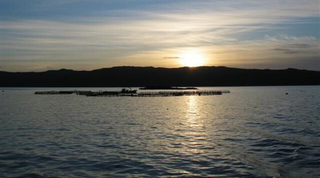 Sunset over fish farm cages.
