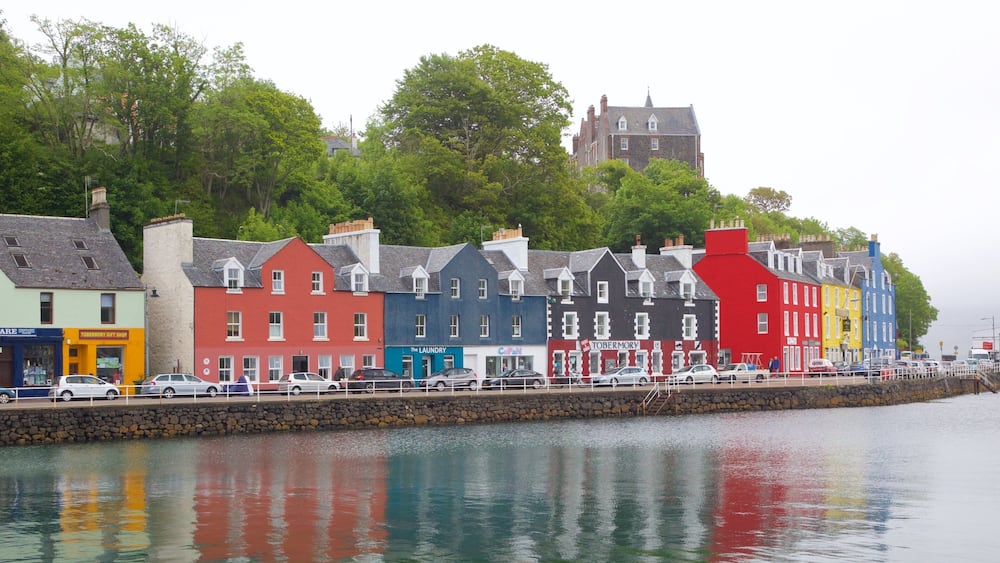 Une promenade en bord de mer, avec des bâtiments aux couleurs vives et un mur de pierre.