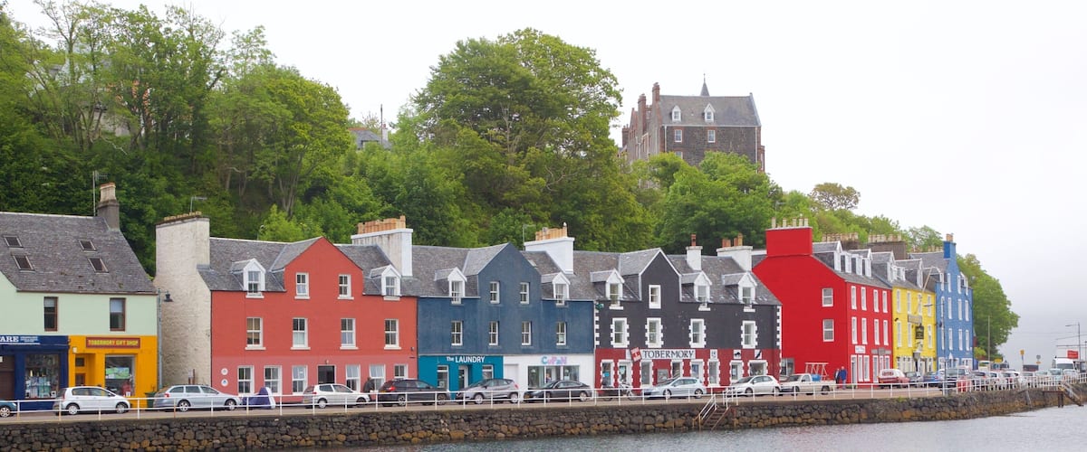 A waterfront with colorful buildings and a stone wall.