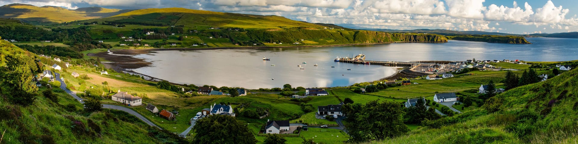 A coastal village with houses, a pier, and a bay.