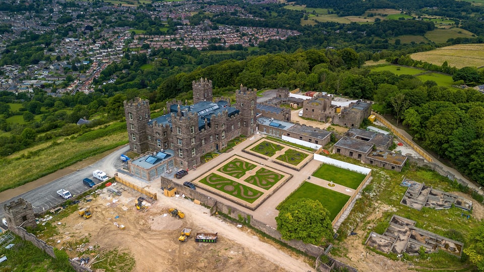 An aerial view of a historic castle with a large courtyard and surrounding landscape.