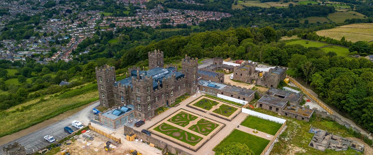An aerial view of a historic castle with a large courtyard and surrounding landscape.